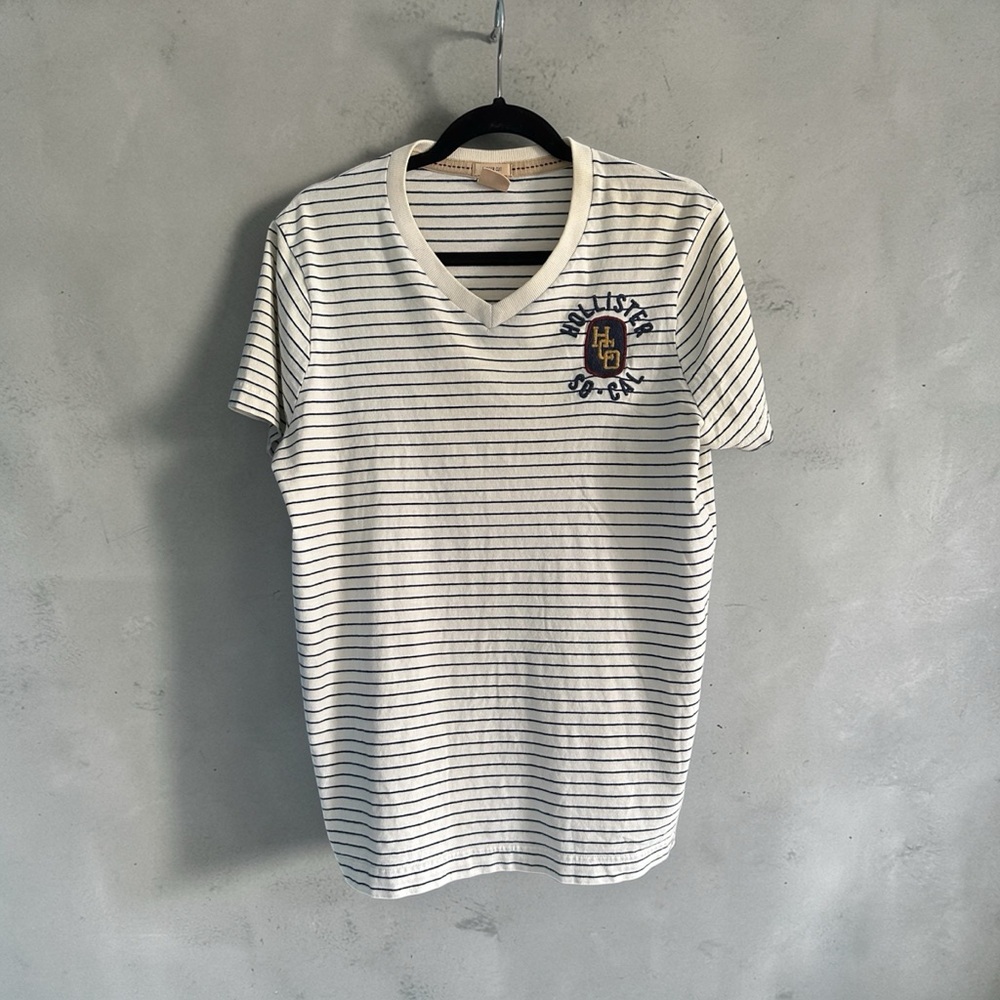 Hollister White V‑Neck Tee with Navy Stripes and Crest